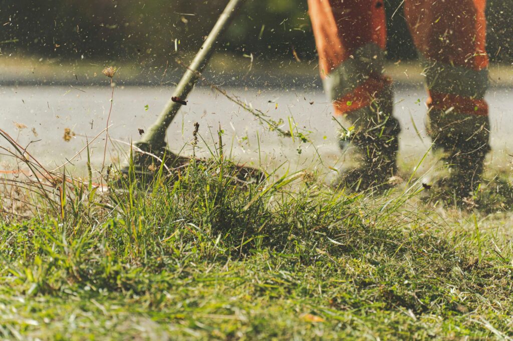 A person using a lawn mower to trim grass in a sunny garden, when knee pain stops you from yard work